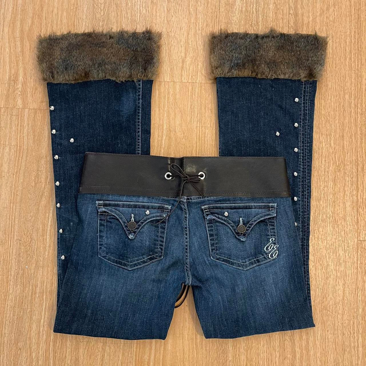 ୨୧ reworked y2k OOAK lowrise flare jeans with thick contrast stitching, eyelets, studs, faux fur cuffs + keychain, and faux leather lace up waist band