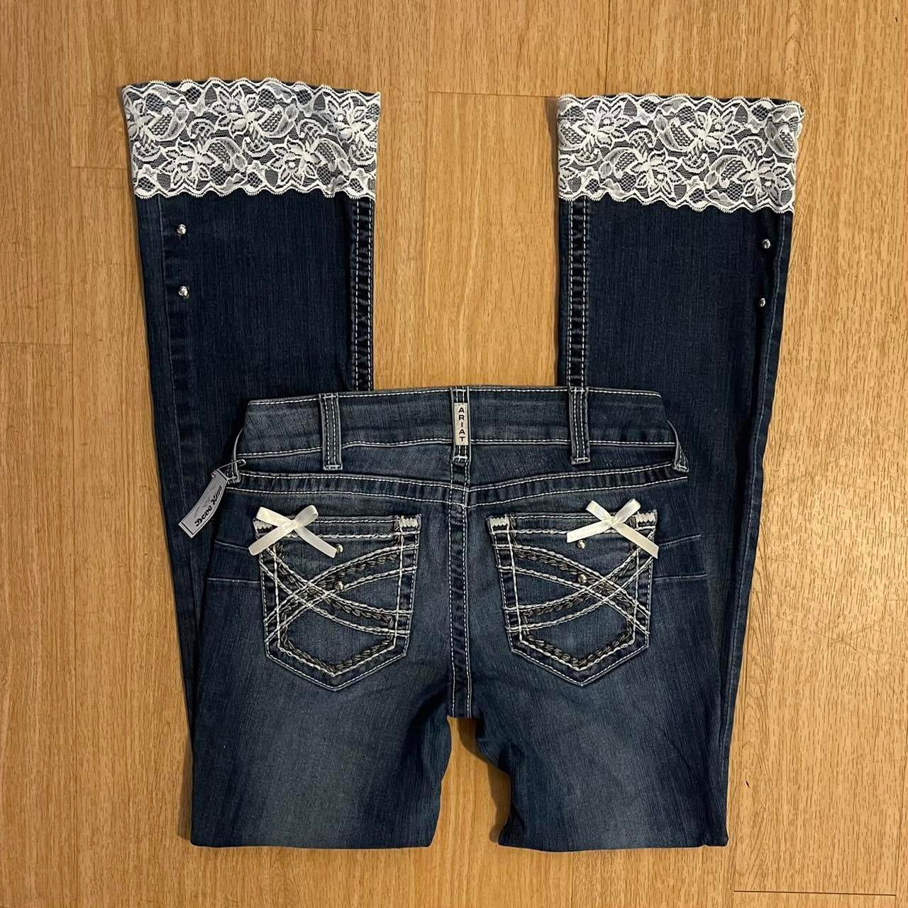 ୨୧ reworked y2k angel princess ooak white ribbon flare ariat jeans with thick contrast stitching, angel wing charm, studs, lace cuffs, lace trim & bows