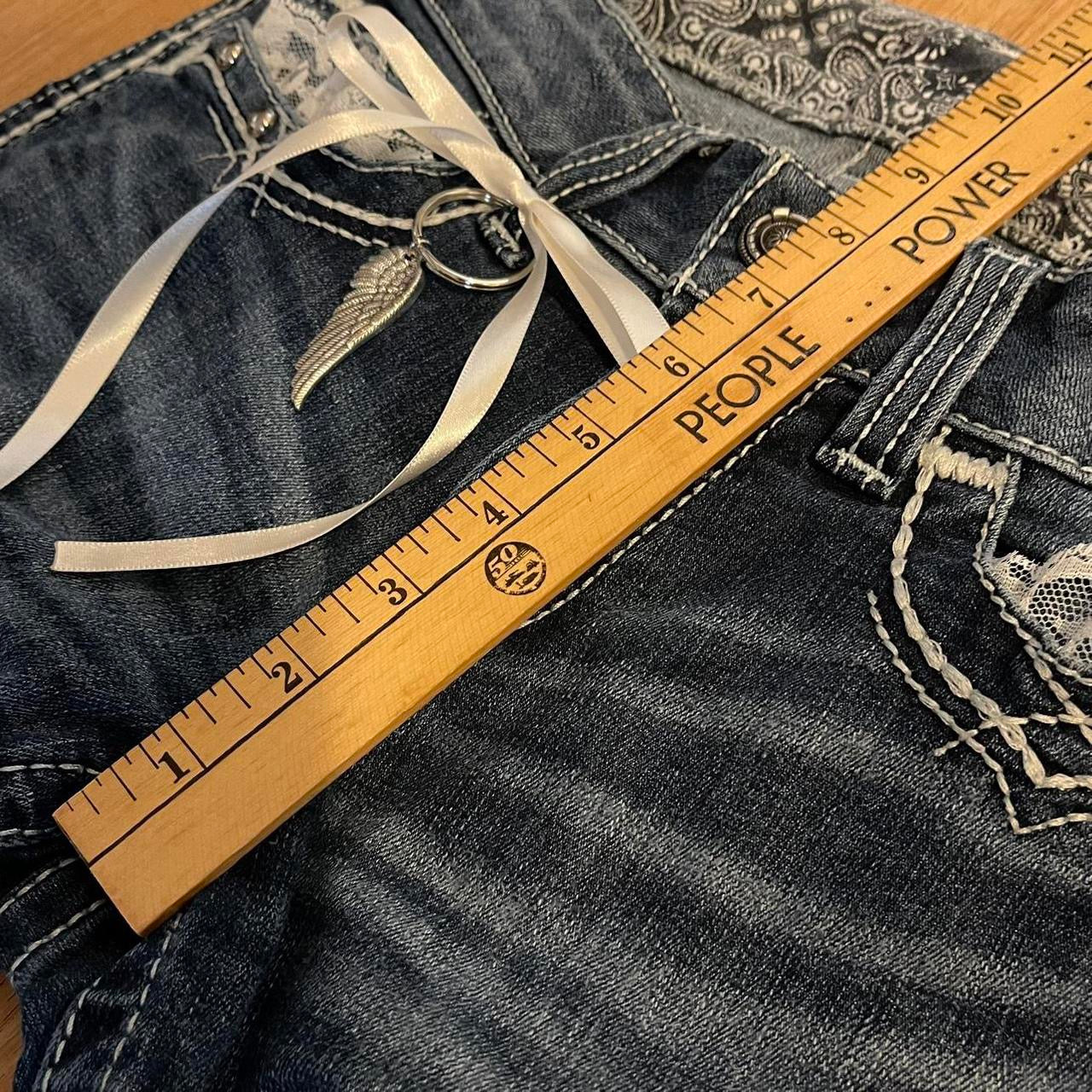 ୨୧ reworked y2k angel princess ooak white ribbon flare ariat jeans with thick contrast stitching, angel wing charm, studs, lace cuffs, lace trim & bows